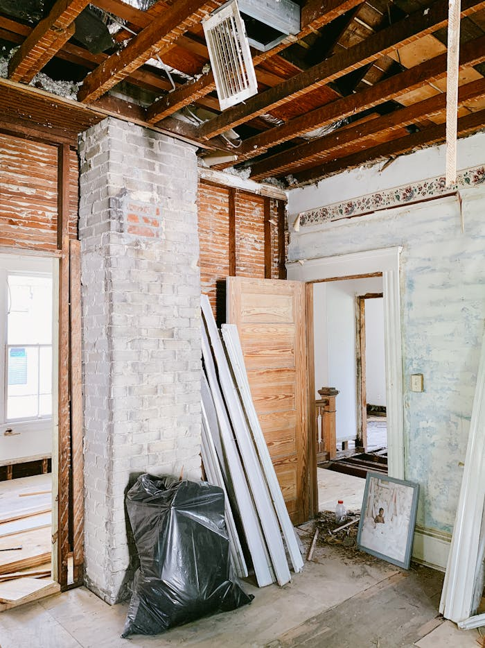 Exposed wooden beams and brickwork highlight a house interior undergoing renovation.